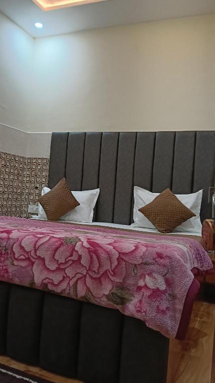 a bedroom with a large bed with a pink blanket at Govind Anand Dham in Vrindāvan