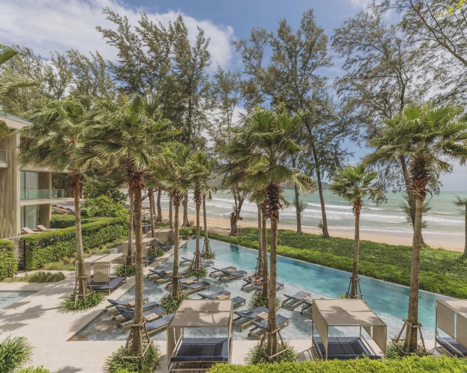 カマラビーチにあるTwinpalms MontAzure Phuketの長椅子とヤシの木のある屋外プール
