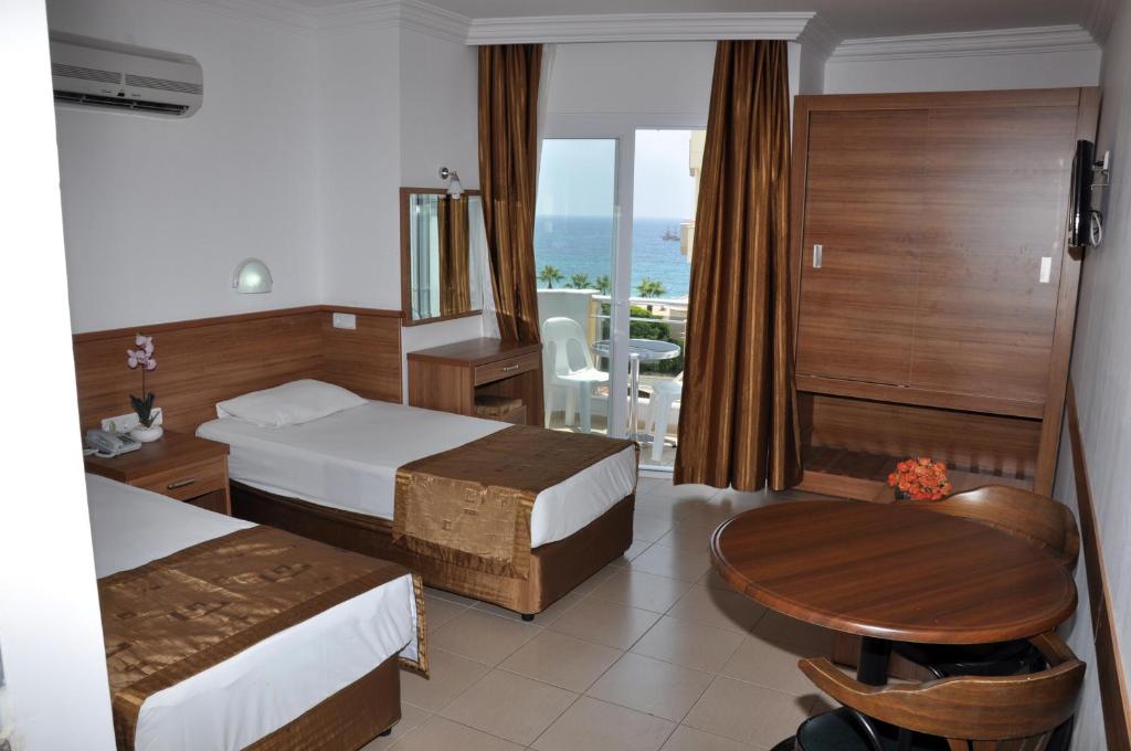 ein Hotelzimmer mit 2 Betten und einem Tisch in der Unterkunft Kleopatra Tuna Apart Hotel in Alanya