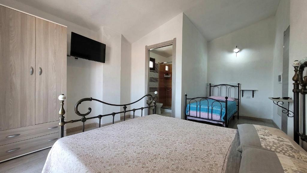 Un dormitorio con una cama y un televisor en la pared. en Casa Grazia Deledda, en Orosei