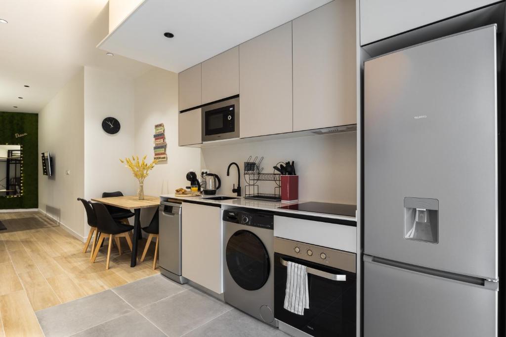 a kitchen with white cabinets and a table with chairs at Apartamento Río Turia 4 in Valencia