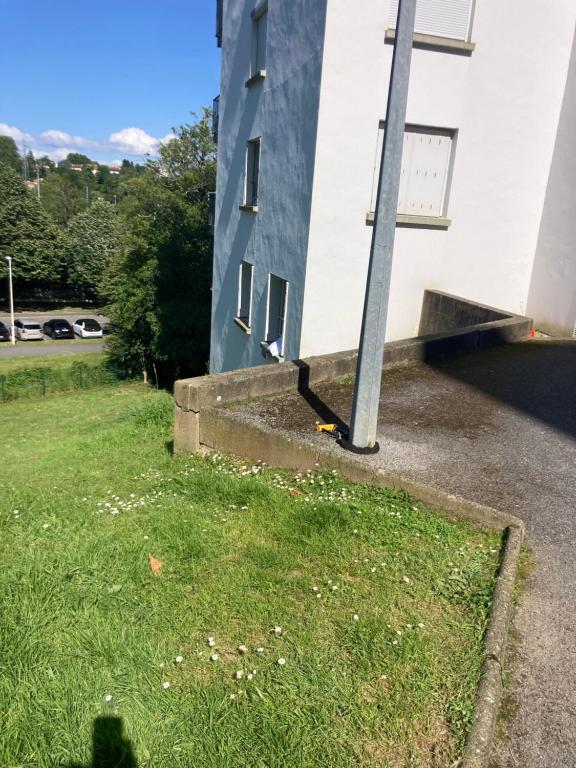un bâtiment avec un poteau à côté d'un terrain en herbe dans l'établissement Studio calme, cosy, lumineux, à Bayonne