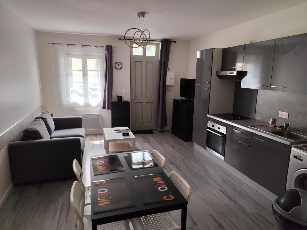 a living room with a couch and a table at Studio meublé centre ville- gare Villers Cotterets in Villers-Cotterêts