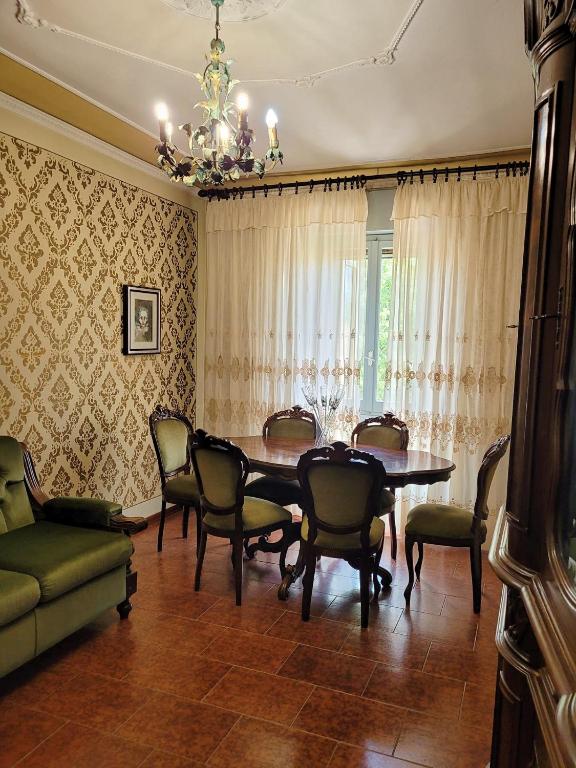 a dining room with a table and chairs and a chandelier at Dolce Sosta Casa Vacanza in Comacchio