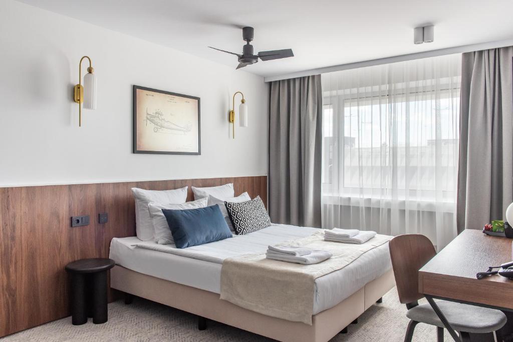 a hotel room with a bed and a desk at AIRINN Vilnius Airport Hotel RENOVATED 2025 in Vilnius