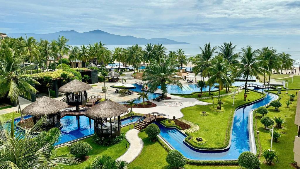 An aerial resort view showing interconnected pools, gardens, cabanas and the sea.