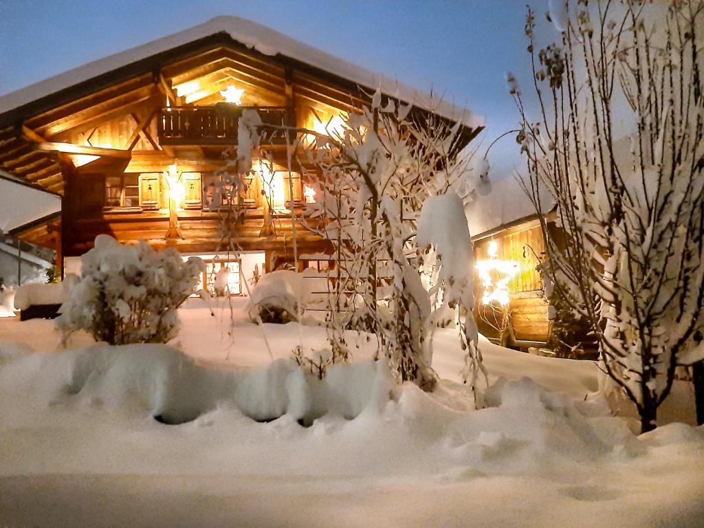 a log cabin in the snow at night at Ferienwohnung Allgäutraum mit Bergblick in Oy-Mittelberg
