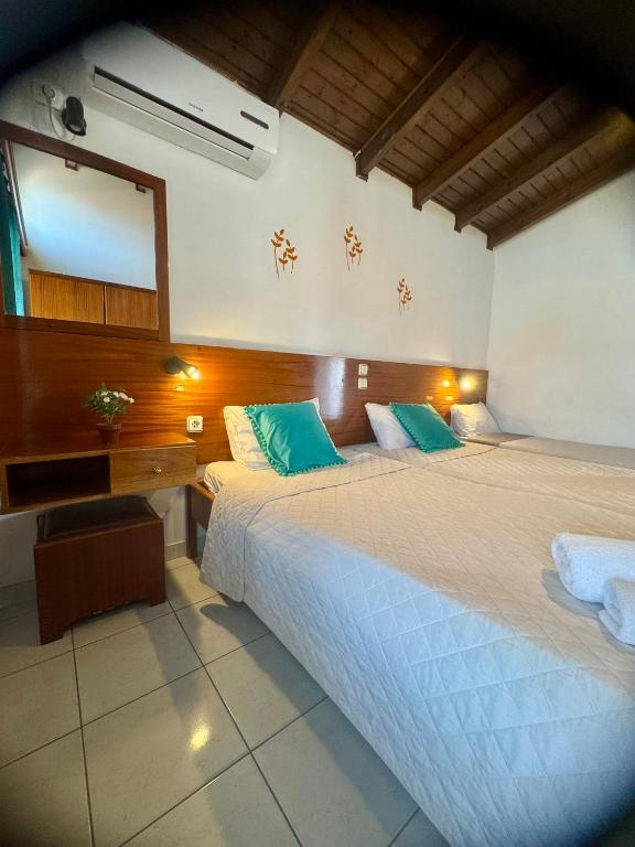una camera da letto con un letto grande e uno specchio di Dionysos Studios a Laganas