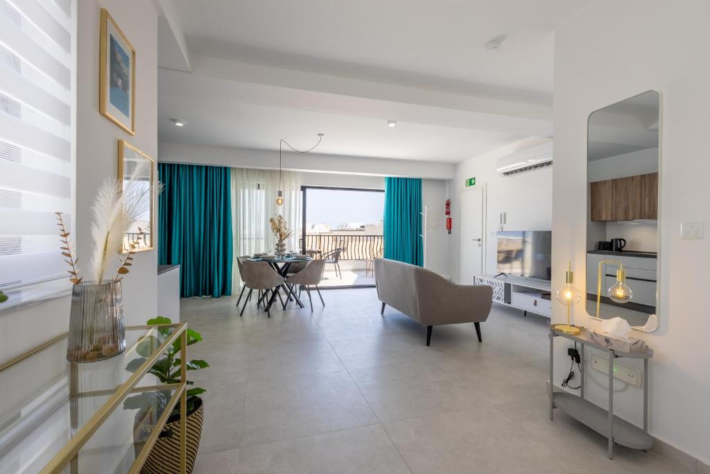 a living room with a table and a dining room at Stylish Side Seaview Penthouse By Quicktrips in St. Paul's Bay