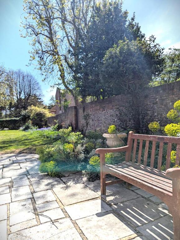 a wooden bench sitting next to a brick wall at East Pallant Bed and Breakfast, Located in Large Georgian Townhouse in Central Chichester in Chichester