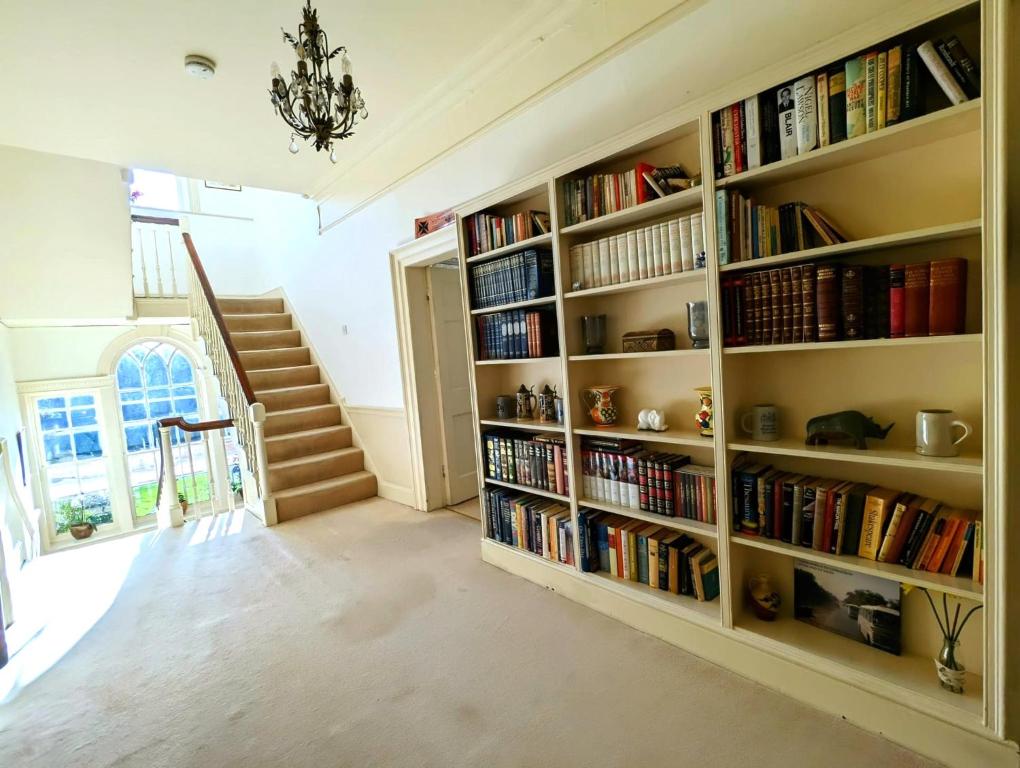 a large book shelf filled with books in a room at East Pallant Bed and Breakfast, Located in Large Georgian Townhouse in Central Chichester in Chichester