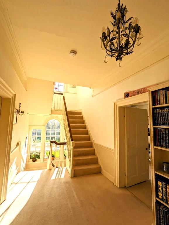 a staircase in a house with a chandelier at East Pallant Bed and Breakfast, Located in Large Georgian Townhouse in Central Chichester in Chichester