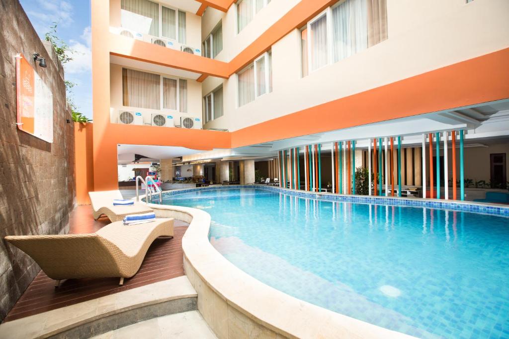 a swimming pool in a hotel with a building at Siesta Legian in Legian