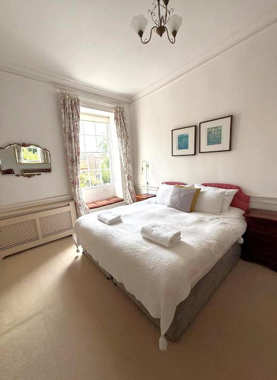 a bedroom with a large bed and a window at East Pallant Bed and Breakfast, Located in Large Georgian Townhouse in Central Chichester in Chichester