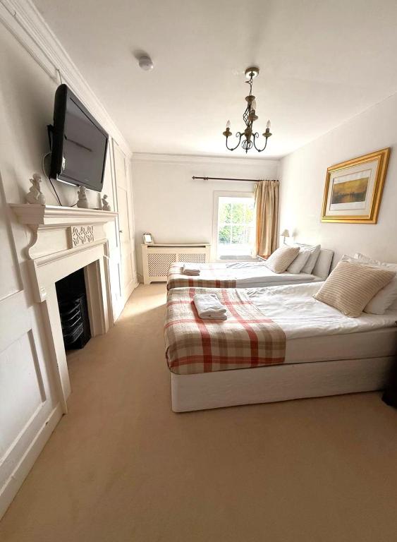 a bedroom with a bed and a tv on the wall at East Pallant Bed and Breakfast, Located in Large Georgian Townhouse in Central Chichester in Chichester