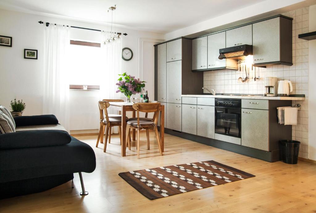 ein Wohnzimmer mit einer Küche und einem Tisch mit Stühlen in der Unterkunft Ferienwohnungen Grimm in Nennslingen