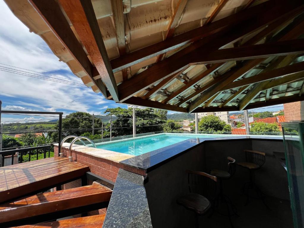 - une piscine avec un banc et une table dans l'établissement Pousada Casa Limão, à Rifaina