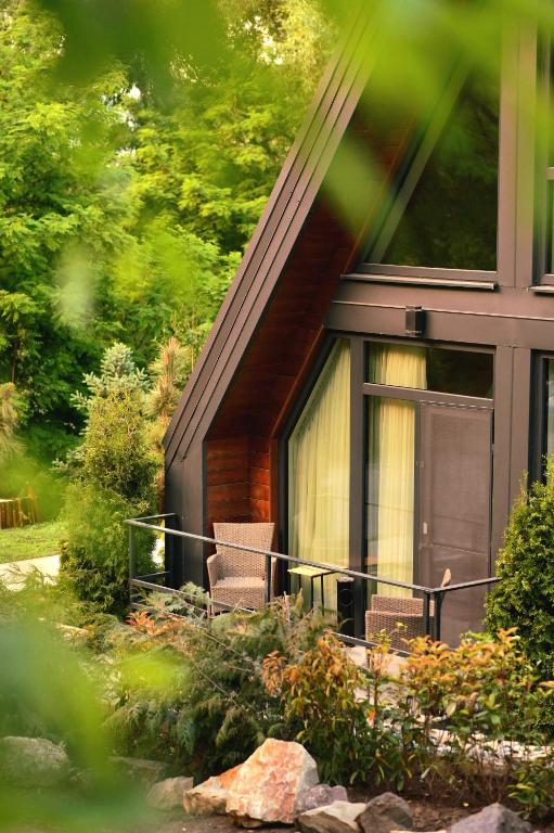 una casa con un porche cubierto con 2 sillas en Chalet by Provence Suceava, en Suceava