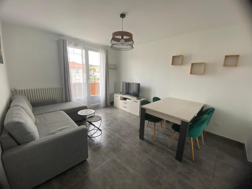 un salon avec un canapé et une table dans l'établissement Bel appartement 2 chambres, proche centre ville - parking, à Vals-près-le-Puy