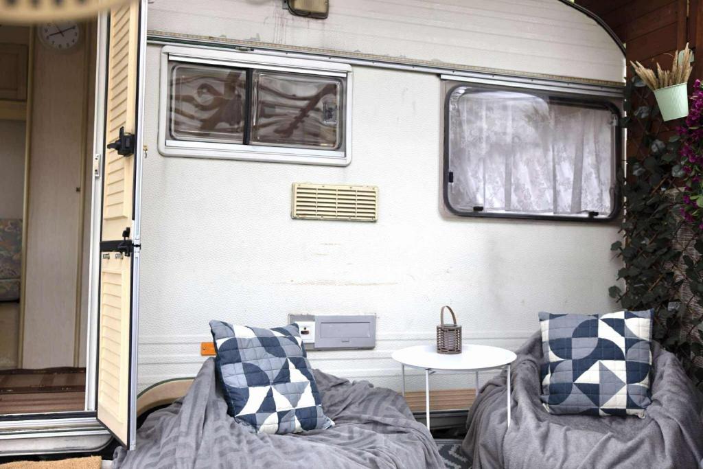 a trailer with two couches and a table in front of it at Noclegi u Renaty Międzybrodzie Bialskie in Międzybrodzie Kobiernickie