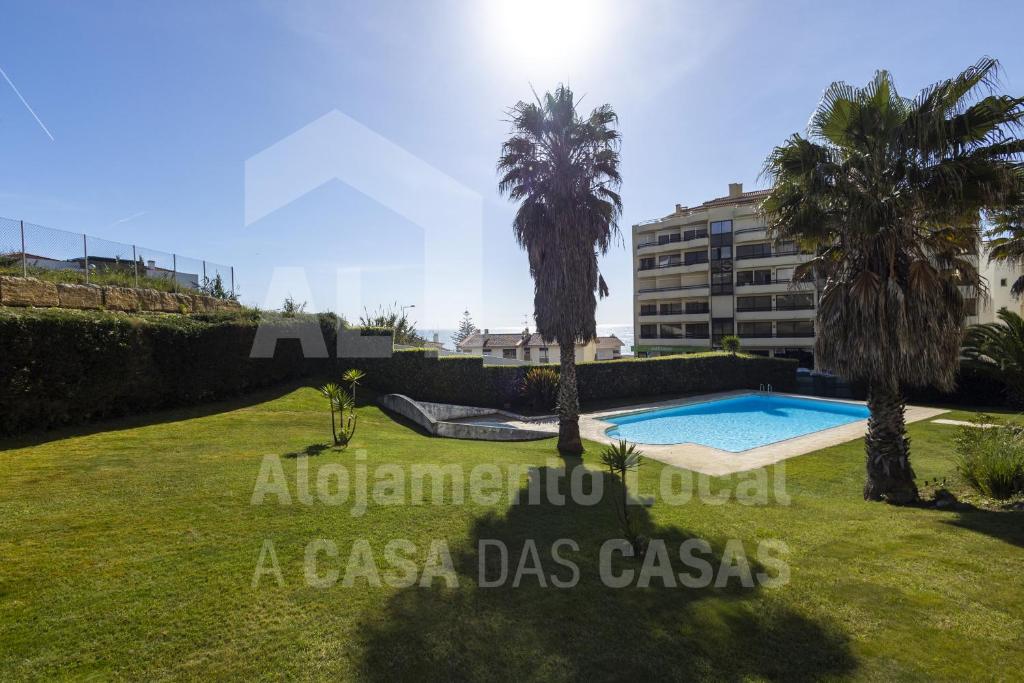 una villa con piscina y palmeras en Apartamento Ouriço by ACasaDasCasas, en Ericeira