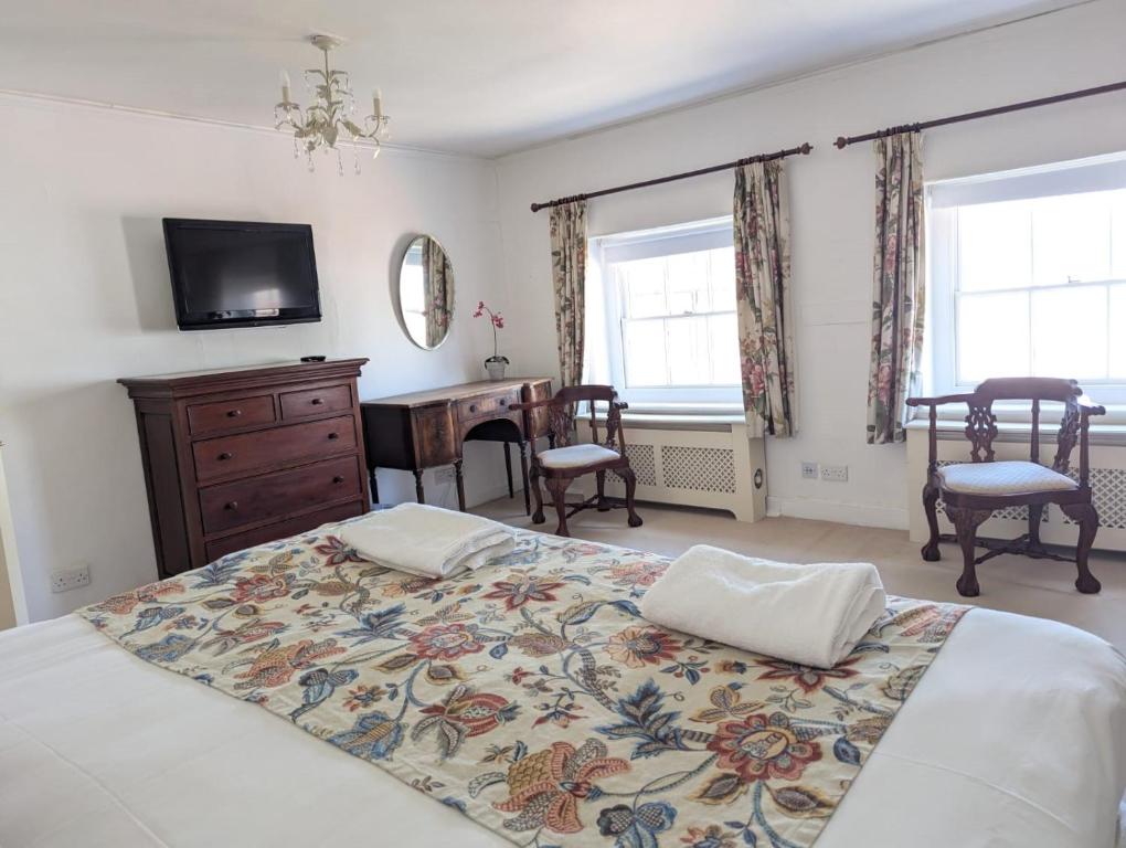 a bedroom with a bed and a desk and a television at East Pallant Bed and Breakfast, Located in Large Georgian Townhouse in Central Chichester in Chichester