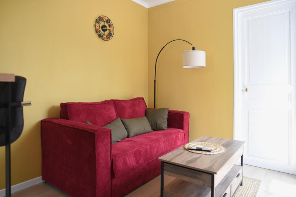 - un canapé rouge dans le salon avec une table dans l'établissement Apartment for 4 - near Square des Batignolles, à Paris