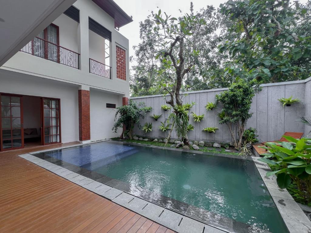 een zwembad voor een huis bij Gee Villas Yogyakarta in Ngingas