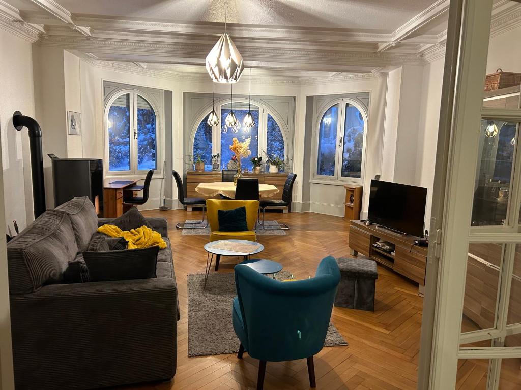 a living room with a couch and a tv at Séjour entre ville et montagnes Appartement 90 m2 in Thann