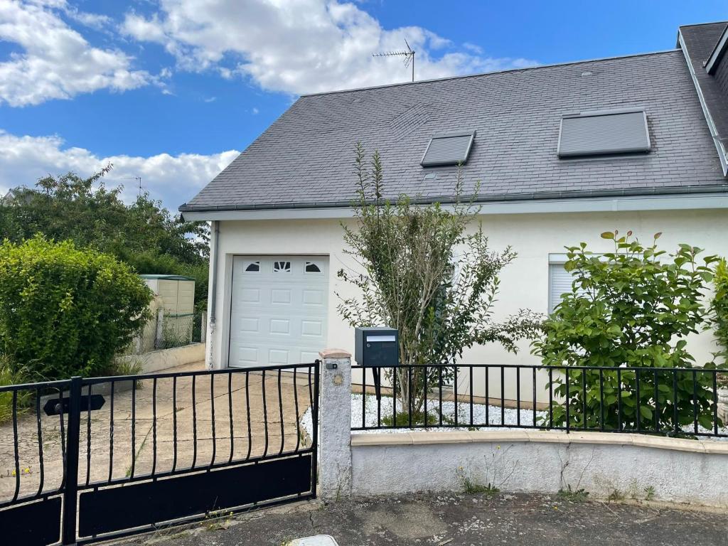 une maison blanche avec un portail et un garage dans l'établissement Maison Cosy à Chartres, à Chartres