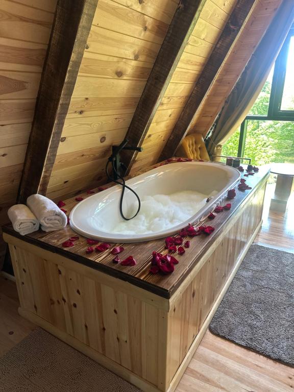 Una bañera en una habitación de madera con flores. en Villa Lazar, en Žabljak