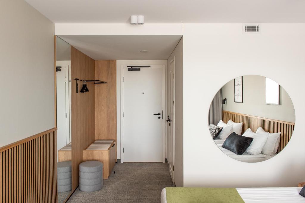 a bedroom with a mirror and a bed at AIRINN Vilnius Airport Hotel RENOVATED 2025 in Vilnius