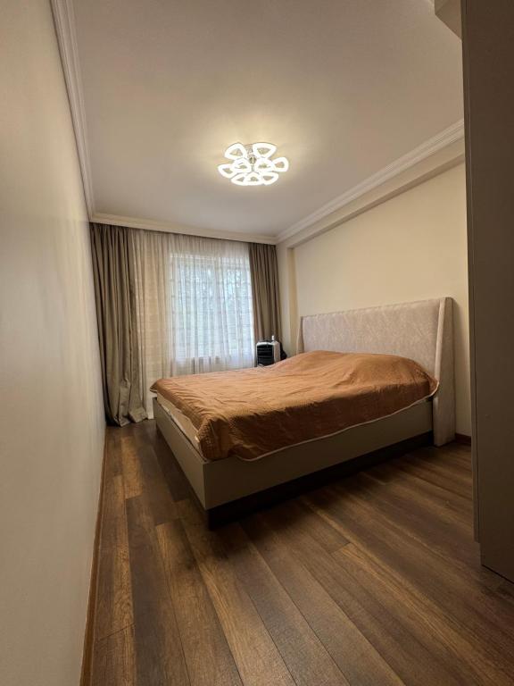 Un dormitorio con una cama en una habitación con ventana. en Kvartira pod kliuch, en Kobuleti