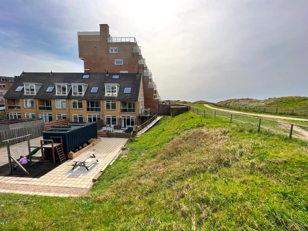 ein Gebäude an der Seite eines grasbewachsenen Hügels in der Unterkunft CasaMare in Egmond aan Zee