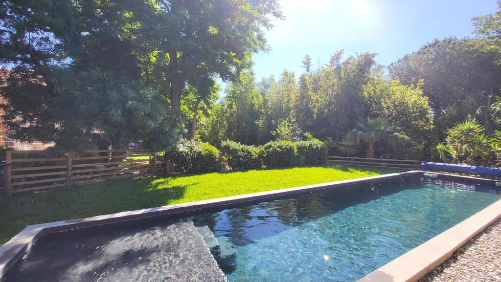 a swimming pool in a yard with a garden at BAMBOU SERENITE ECO LOGIS -Piscine in Elne