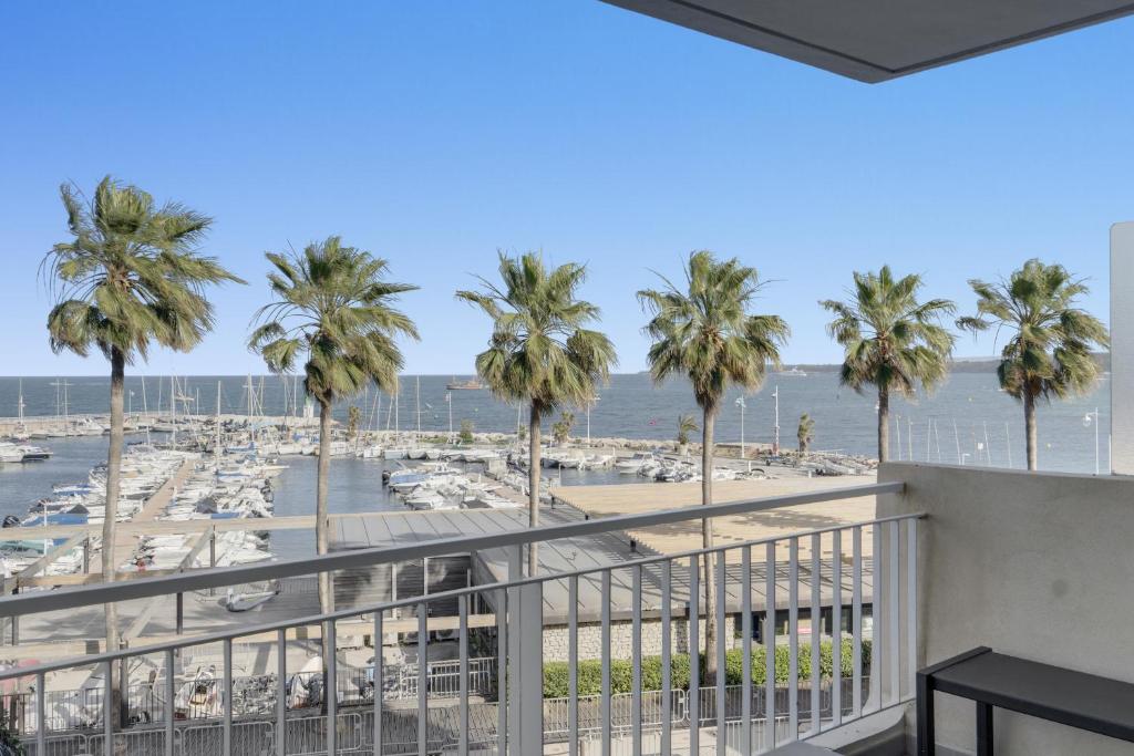 - un balcon avec des palmiers offrant une vue sur la plage dans l'établissement F2 Palm Beach - Pointe Croisette, à Cannes