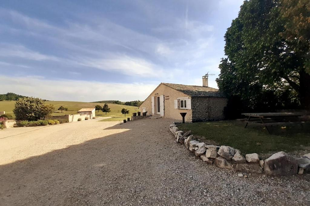 une maison sur une route en gravier à côté d'un bâtiment dans l'établissement La Grange d'Anthounin, à Redortiers
