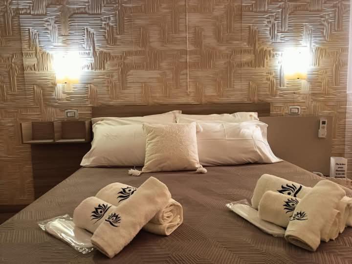 łóżko z 3 poduszkami na górze w obiekcie Casa Vacanze Fiore di Loto w mieście Leporano