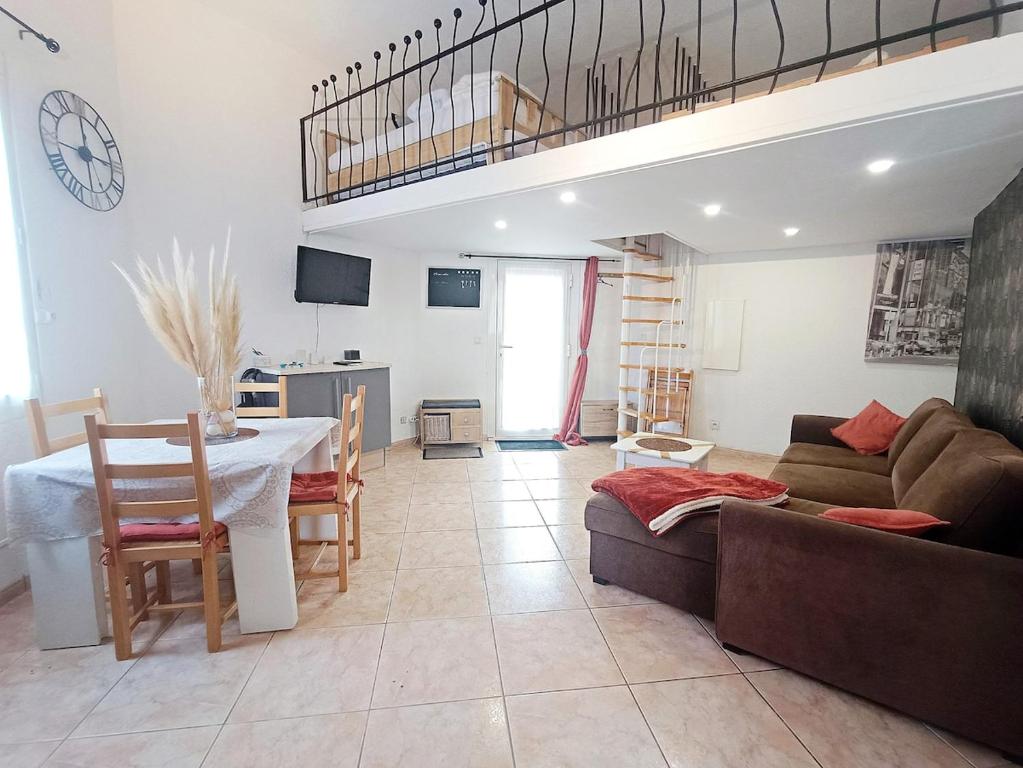 un salon avec un canapé et une table dans l'établissement Duplex Cosy, piscine, Lac, au Barcarès