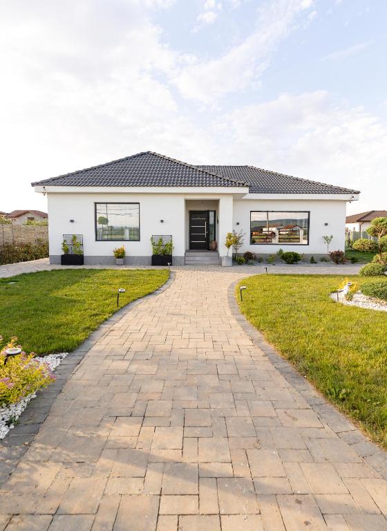 a white house with a brick driveway at Amavi Homes With Garden in Alba Iulia