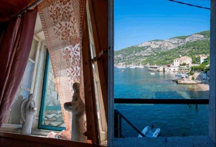 een open raam met uitzicht op het water bij Apartma Maggie in Komiža