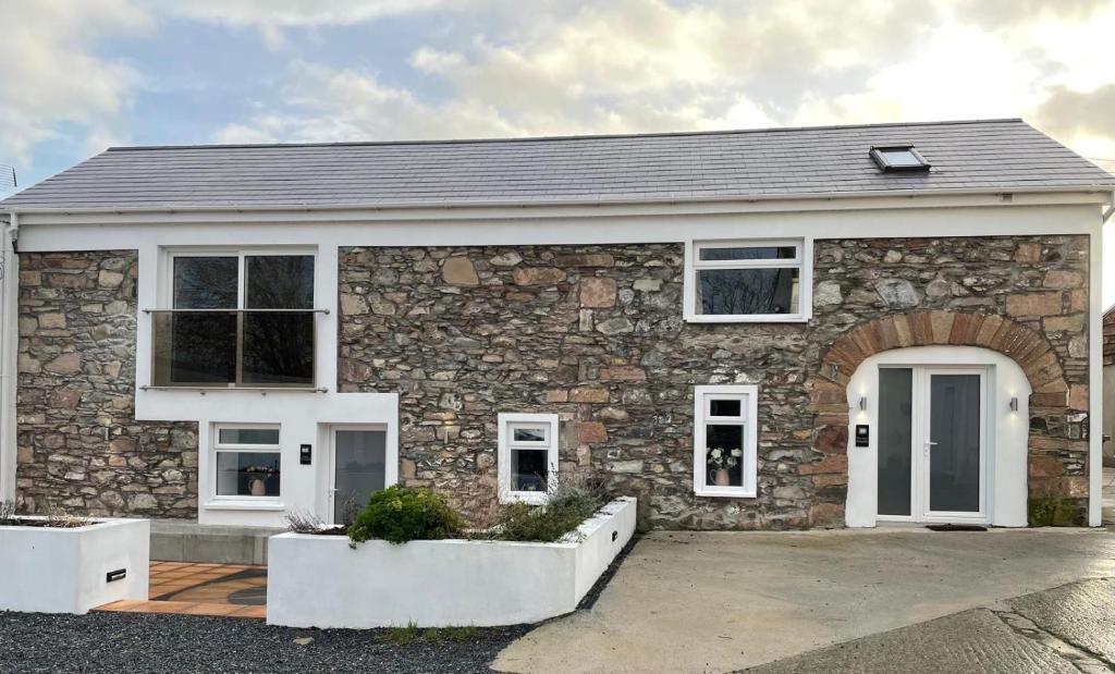 a brick house with a stone facade at Merok Mill House & Old Granary in Six Road Ends
