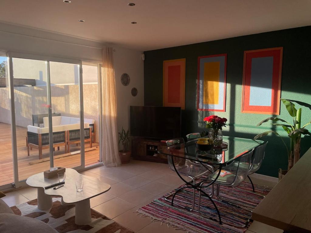 un salon avec une table en verre et une télévision dans l'établissement House with terrace near center, à Perpignan
