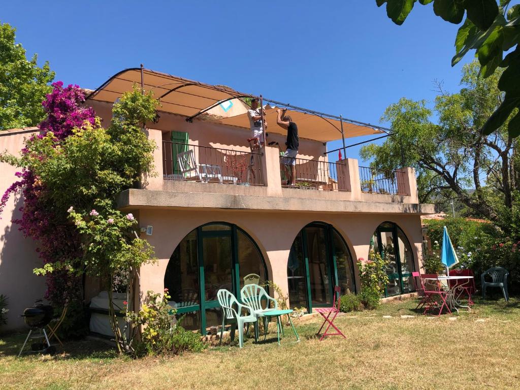 Cette maison dispose d'un balcon avec des chaises et des tables. dans l'établissement La Bastide Dambrine, à Sanary-sur-Mer