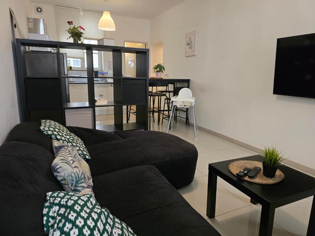 un salon avec un canapé noir et une table dans l'établissement Le Cinq, à Metz