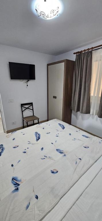 a bedroom with a bed with blue flowers on it at Apartament Georgiana in Văleni