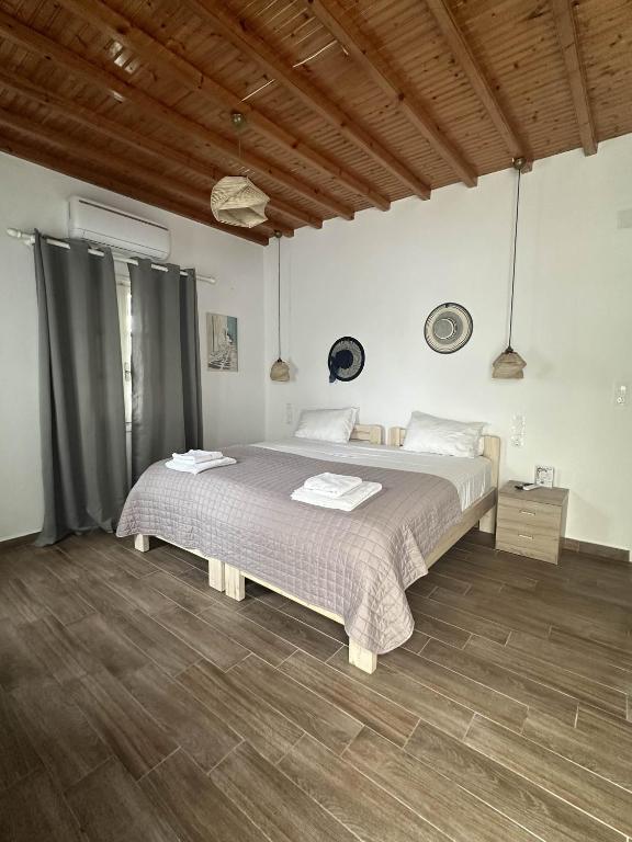 ein Schlafzimmer mit einem großen Bett und einem Holzboden in der Unterkunft Alesta in Aggelika