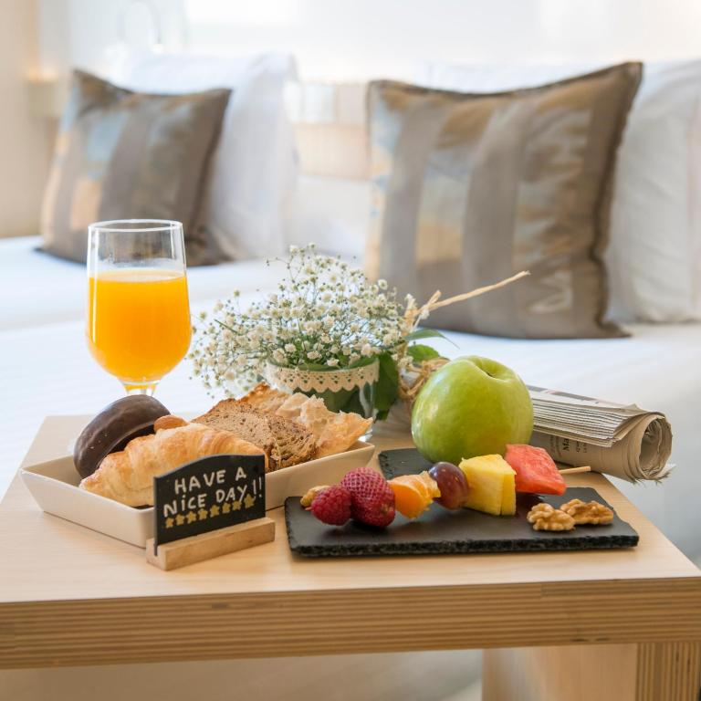 una bandeja de comida en una mesa con un vaso de zumo de naranja en Ako Suite Hotel, en Barcelona