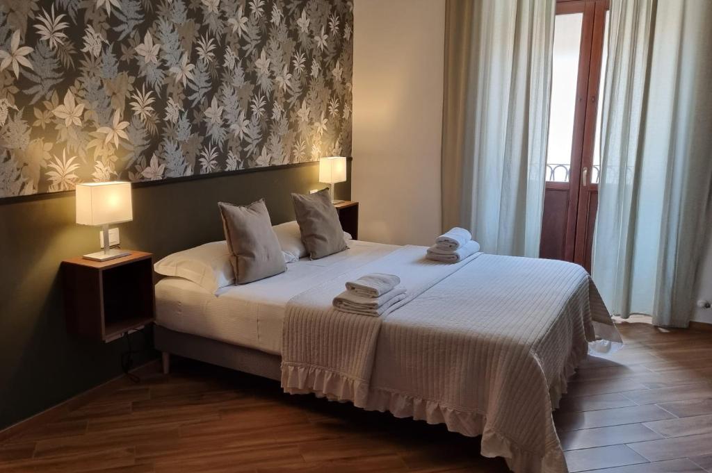 une chambre avec un lit avec deux serviettes dessus dans l'établissement Antica Dimora San Crisante - centro storico, à LʼAquila