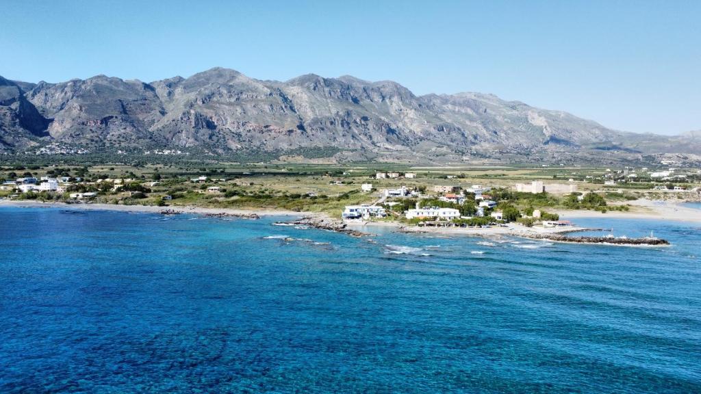 an island in the ocean with mountains in the background at Coral in Frangokastello